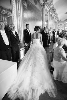 a woman in a wedding dress standing next to a man