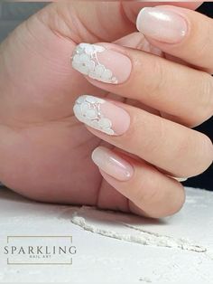 a woman's hand with french manies and white flowers on it, while she is