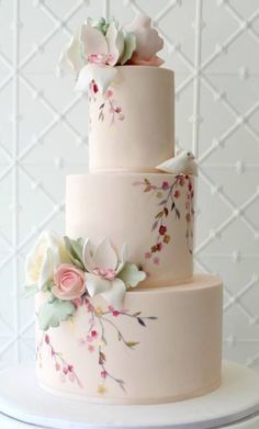 a three tiered cake decorated with flowers and birds