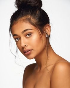 a beautiful young woman posing with her hair in a topknoted up bun