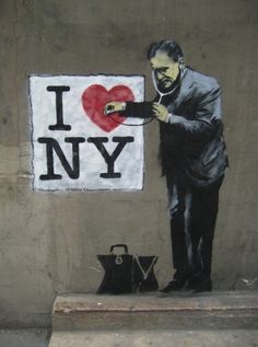 a man in a suit and tie standing next to a sign that says i love new york