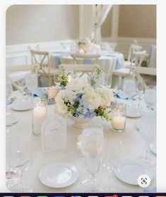 the table is set with white and blue flowers