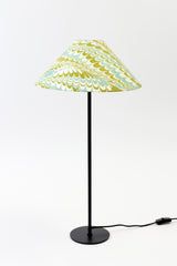 a lamp that is sitting on top of a white surface with a cord attached to it