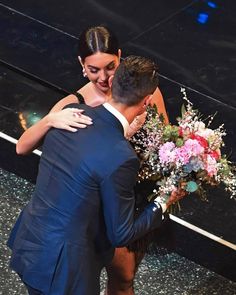 a man and woman hugging each other on stage