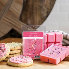 pink frosted cookies with sprinkles are on the table