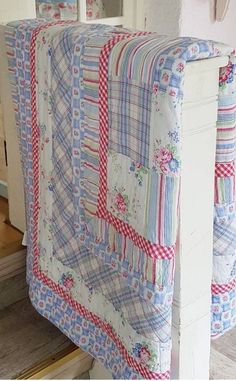 a quilted bed spread sitting on top of a wooden floor