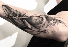 a woman's arm with a black and white tattoo design on her left arm