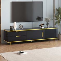 a living room with a large television on top of a wooden entertainment center next to a potted plant