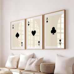 two framed cards are hanging on the wall above a bench with pillows and throw pillows