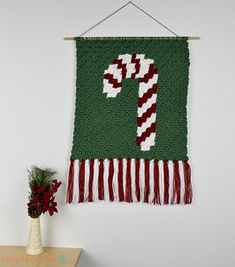 a green wall hanging with a candy cane on it