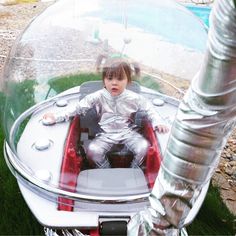 a young boy sitting in a futuristic vehicle