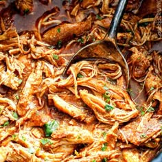 a skillet filled with pasta and meats being stirred by a ladle in it