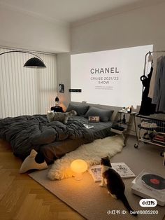 a cat sitting on the floor next to a bed