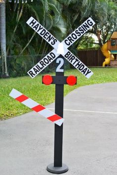 a railroad crossing birthday sign on the sidewalk