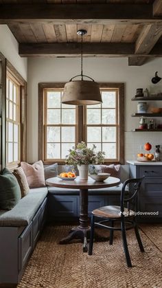 a kitchen with a table and chairs next to a window filled with fruit on the counter