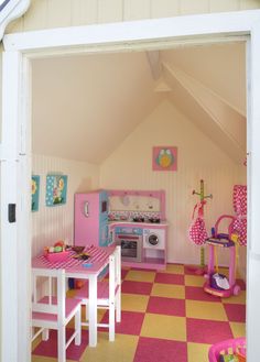 a play kitchen with pink and yellow checkered flooring in a child's room