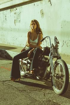 a woman sitting on top of a motorcycle