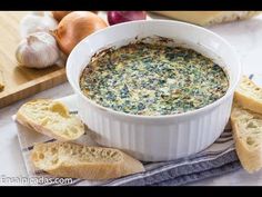 a bowl of spinach dip with garlic bread on the side