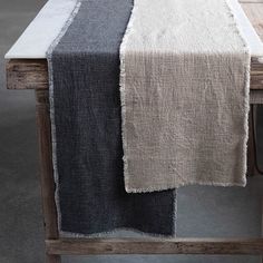 a table with a black and white runner on it, next to a wooden chair