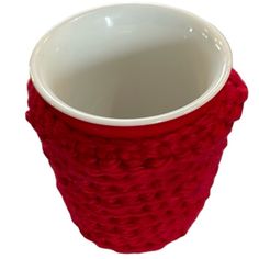 a red knitted cup cozys up in the shape of a basket