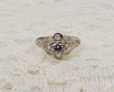 Vintage Art Deco 18k white gold old European diamond engagement ring. The ring is in excellent condition with little noticeable wear with a beautiful mounting design. The ring features one primary round old European cut diamond weighing approximately 0.55cts total weight with a color of J-K and clarity of SI2. It has four round modern and old European cut diamonds on either side weighing approximately 0.20cts total weight with a color of J and a clarity of SI1-SI2. The ring is 1.69mm wide at the Victorian White Brilliant Cut Diamond Ring, White Victorian Style Brilliant Cut Diamond Ring, Vintage White Diamond Ring In 14k White Gold, Victorian White Diamond Ring With Prong Setting, Vintage 14k White Gold White Diamond Ring, Diamond White Solitaire Diamond Ring For Marriage, Diamond White Solitaire Ring For Marriage, White Gold Solitaire Diamond Ring For Marriage, Solitaire Diamond White Diamond Ring For Marriage