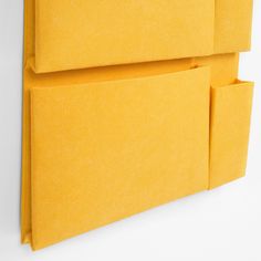 two yellow envelopes are hanging on the wall next to each other, one is open