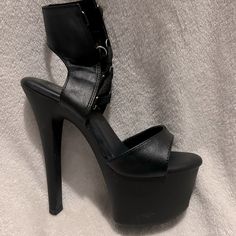 Black Brand New In The Box Pleasers Black Round Toe Heels For Night Out, Black Synthetic Heels For Club, Edgy Black Synthetic Heels, Black Heels With Heel Strap For Night Out, Edgy Black High Heel Shoes, Black Heels With Reinforced Heel For Night Out, Black Platform Heels For Night Out, Black Leather Heels For Party, Black Edgy Heels For Evening