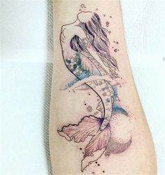 a woman's leg with a fish tattoo on the left side of her arm