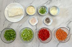 seven bowls filled with different types of food on top of a marble countertop next to each other