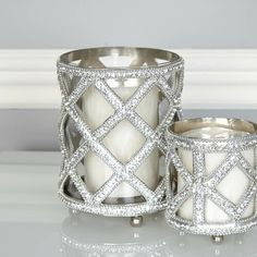 two white candles sitting next to each other on a table