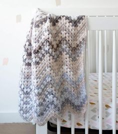 a crocheted blanket draped over a white crib