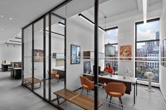 an office with glass walls and wooden benches