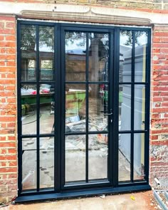 an image of a black double doors in front of a brick building that is being renovated