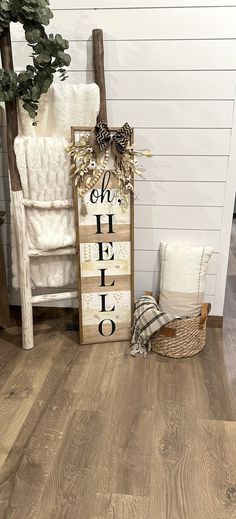 a wooden sign sitting on top of a hard wood floor next to a white chair