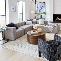 a living room with couches, chairs and a fire place in the middle of it