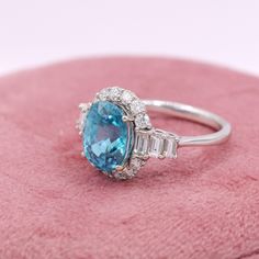 This stunning 6-carat oval-cut blue zircon has a light blue color with the perfect amount of dark flashes. An absolutely stunning ring for an engagement or any kind of statement! This NNJ Designs' original ring setting features a mix of round and baguette natural earth-mined diamonds creating an elegant and beautiful ring! This ring can be a lovely December birthstone gift for your loved ones! As listed, this ring is ready to ship. If you're interested in purchasing this setting with a different Oval Light Blue Topaz Ring With Prong Setting, Fine Jewelry Light Blue Oval Topaz Ring, Light Blue Oval Topaz Ring With Prong Setting, Gia Certified Oval Aquamarine Jewelry, Gia Certified Oval Blue Topaz Ring, Oval Turquoise Topaz Ring For Wedding, Gia Certified Oval Topaz Ring For Gift, Gia Certified Oval Topaz Ring As Gift, Blue Oval Topaz Ring With Halo Setting