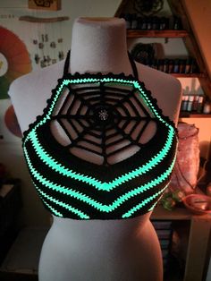 a mannequin wearing a black and green bralet with neon lights on it