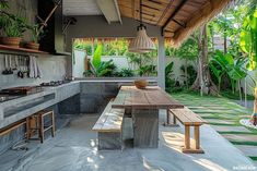 an outdoor kitchen with wooden table and benches