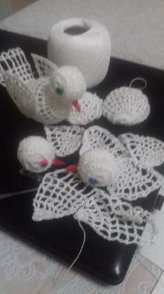 white crocheted items are sitting on a black tray