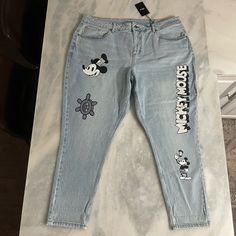 a pair of jeans with mickey mouse patches on them