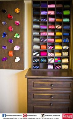 a wooden cabinet with many different types of ties on it and a wall hanging in the background