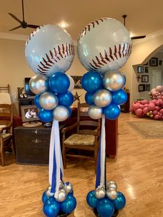 two baseball balloons are on top of each other in the middle of a living room