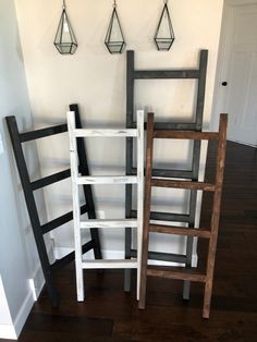 three wooden ladders sitting next to each other on the floor in front of a white wall