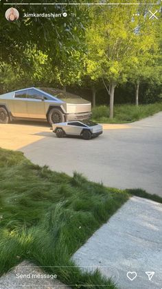 two cars parked in front of a house on a street with grass growing all around