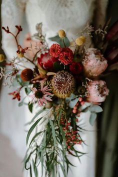 a woman holding a bouquet of flowers in her hands