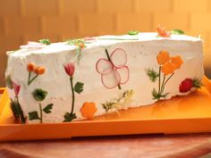 a cake decorated with flowers on an orange plate