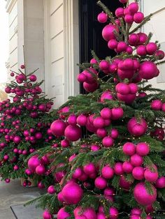 pink christmas ornaments are lined up on the outside of a house