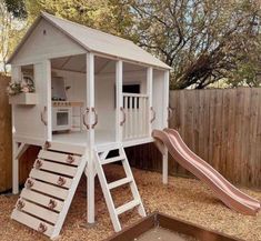 a white house with a red sale sign in front of it and a wooden slide