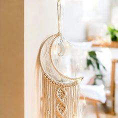 a white dream catcher hanging from the side of a wall