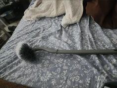 a hair dryer sitting on top of a bed next to a blanket and pillow